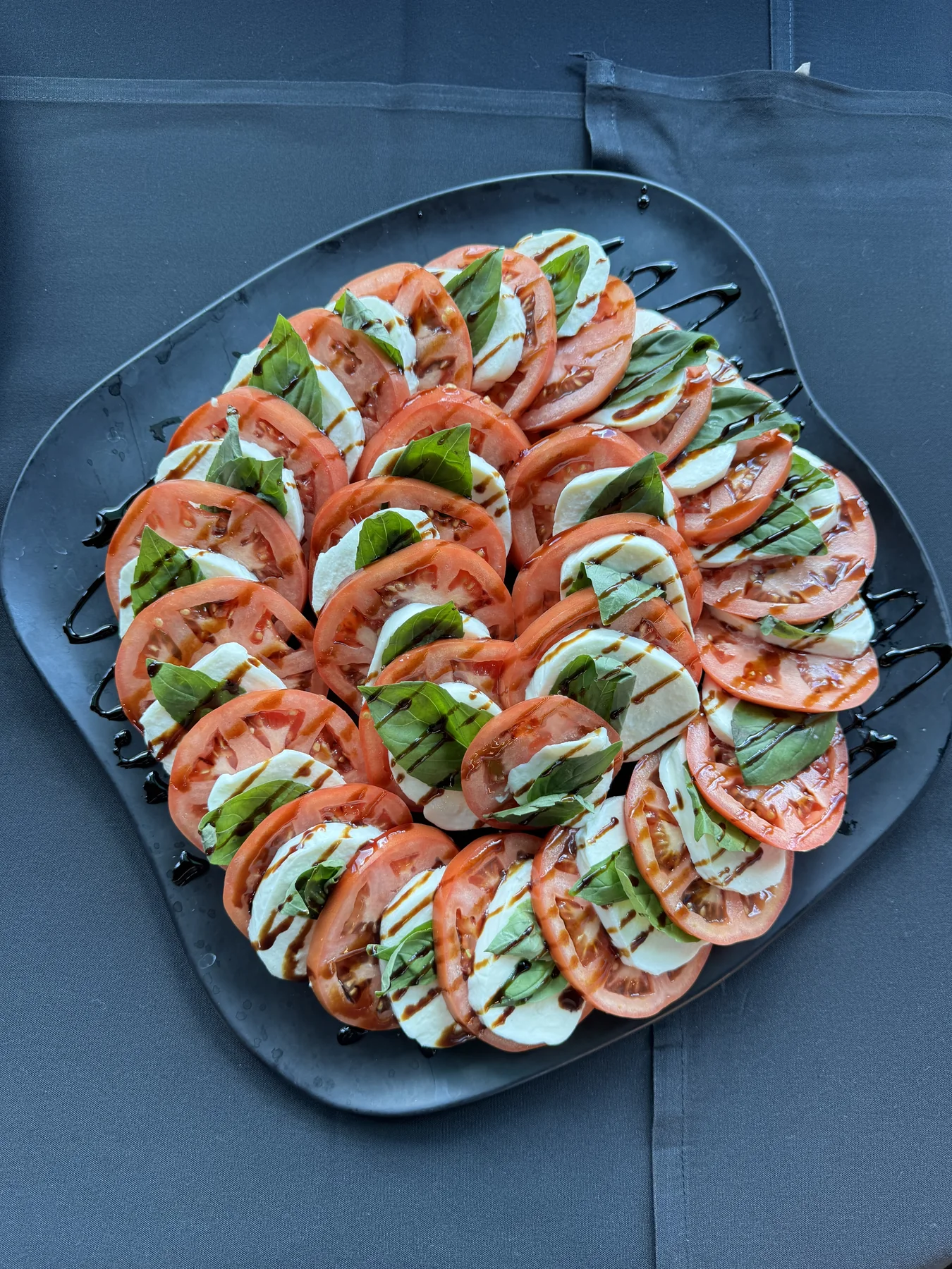 Caprese platter with sliced tomatoes, mozzarella, basil and balsamic glaze